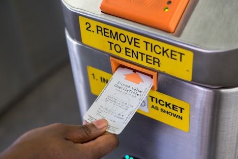 Customer inserting a CharlieTicke into a fare entry gate